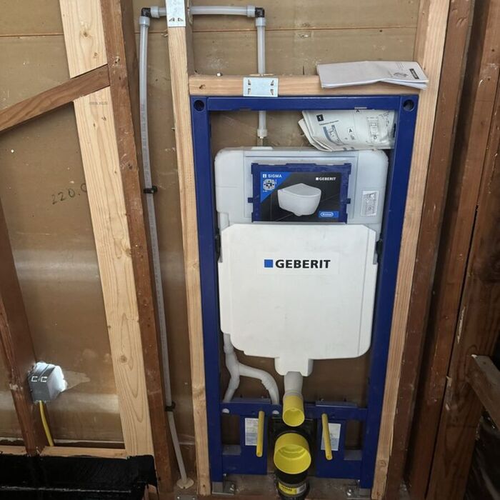 Geberit in-wall toilet carrier system installed in wall framing before drywall, ready for a wall-hung toilet