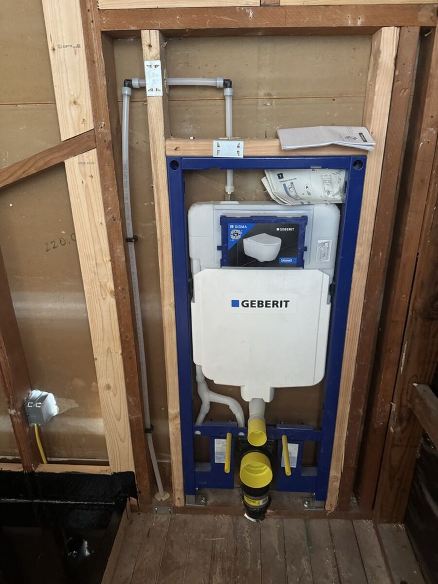 Geberit in-wall toilet carrier system installed in wall framing before drywall, ready for a wall-hung toilet