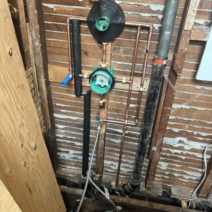 Copper manifold with a pressure-reducing valve, expansion tank connections and gas shutoff installed on a residential system